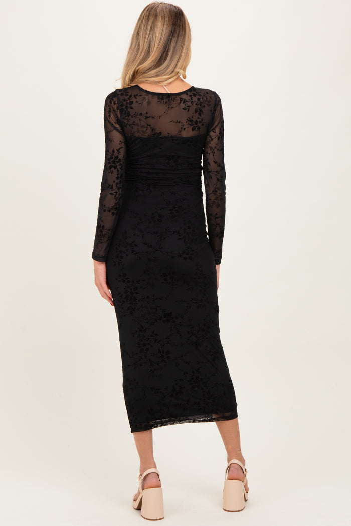 woman wearing a black maternity dress with long sleeves and floral lace detailing, shown from the back