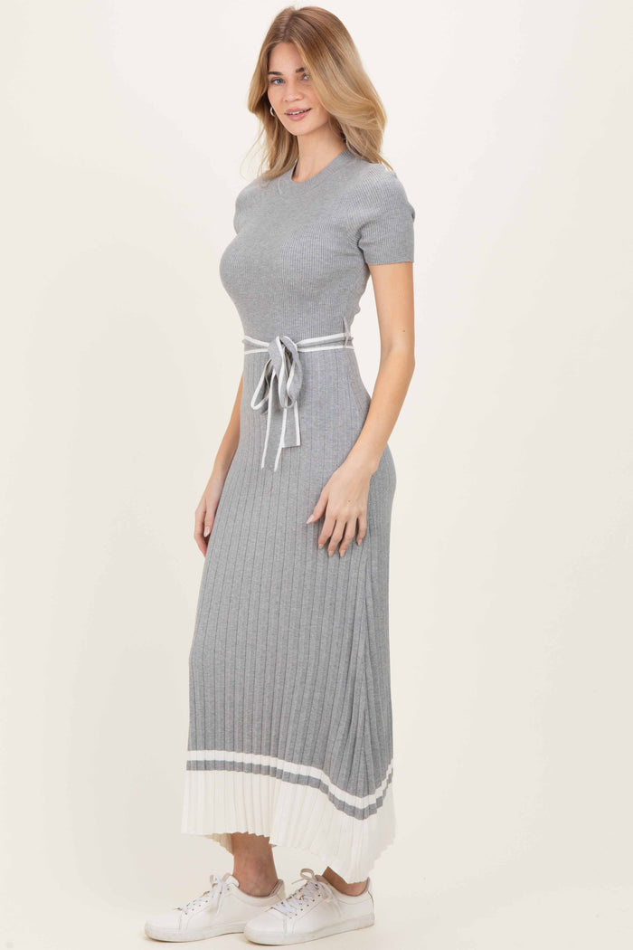 woman wearing a gray ribbed maxi dress with short sleeves and a tie waist detail, styled with white sneakers