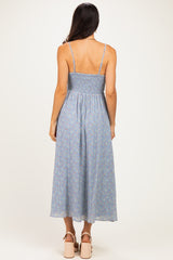 woman wearing a blue floral print maxi dress with smocked back and thin straps