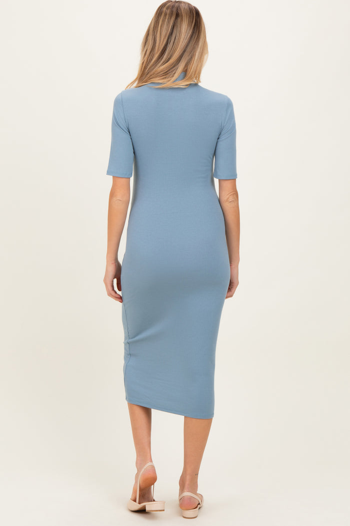 woman wearing a light blue ribbed maternity midi dress with short sleeves and a fitted silhouette