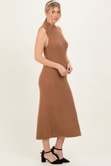 woman wearing a tan sleeveless ribbed knit midi dress with a high neckline and side slit