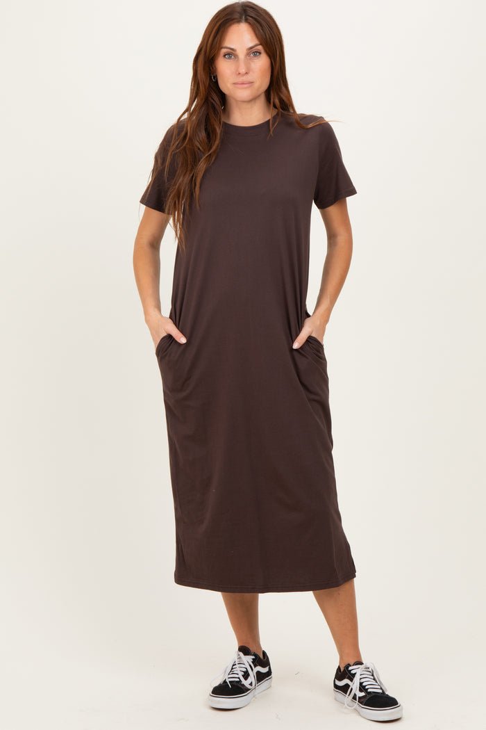woman wearing a dark brown short sleeve midi dress with side pockets and casual sneakers