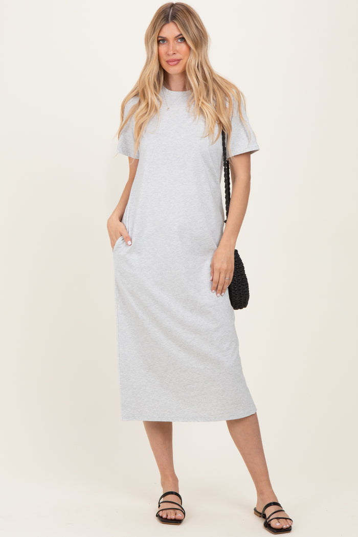 woman wearing a grey short sleeve maxi dress with pockets and holding a black woven bag
