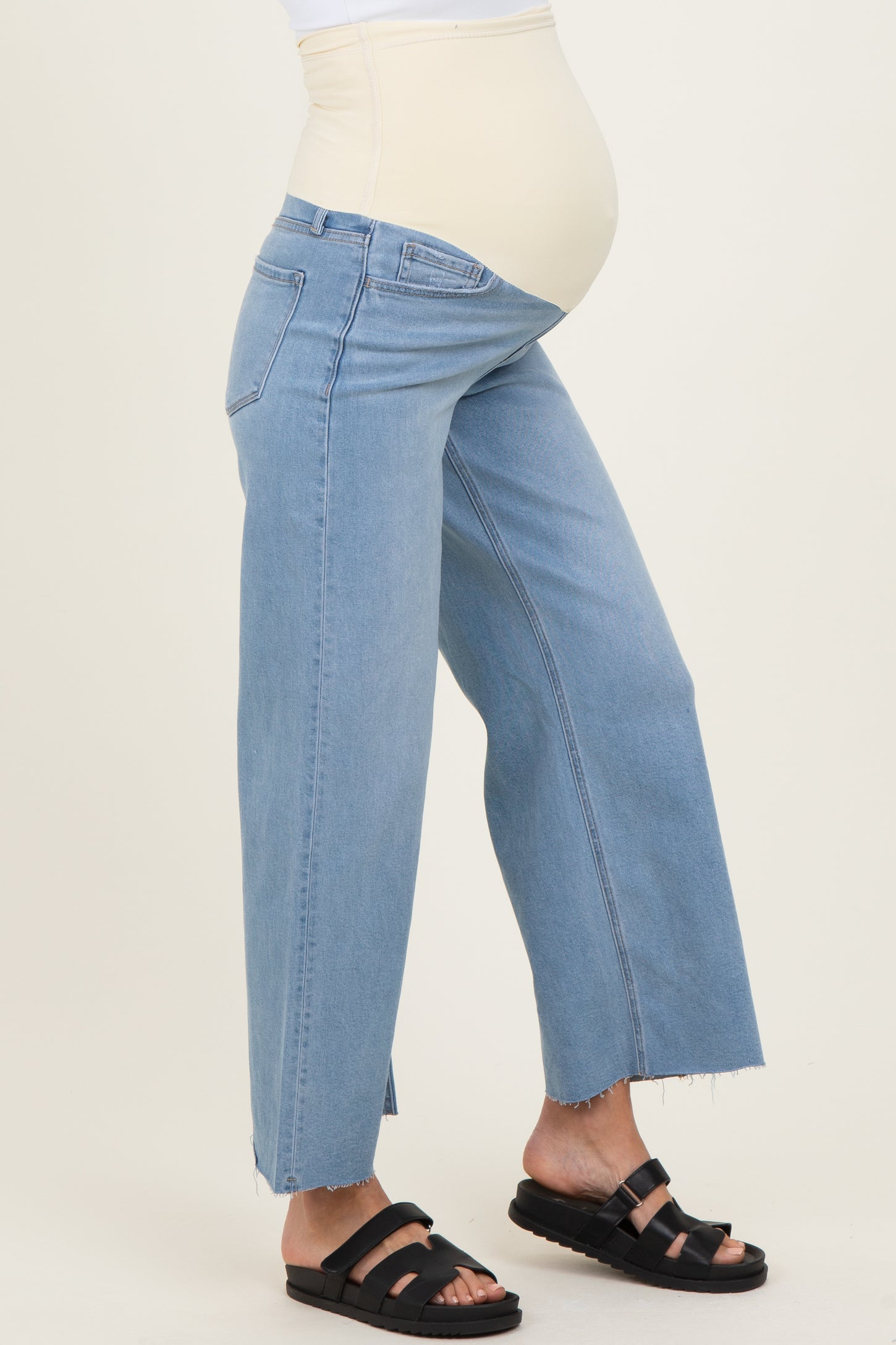 woman wearing light blue maternity wide-leg jeans with a supportive waistband and a visible baby bump