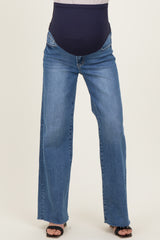 woman wearing a pair of light wash maternity jeans with a black over-the-bump panel and a relaxed fit