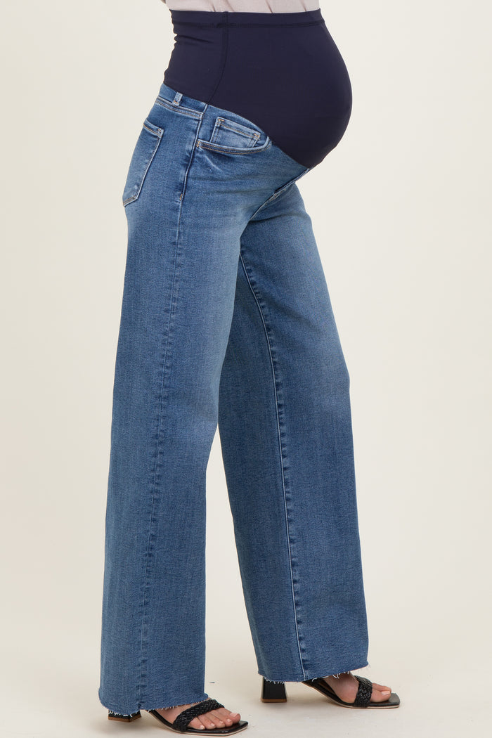 woman wearing a pair of wide-leg blue maternity jeans with a stretchy black waistband and a visible baby bump