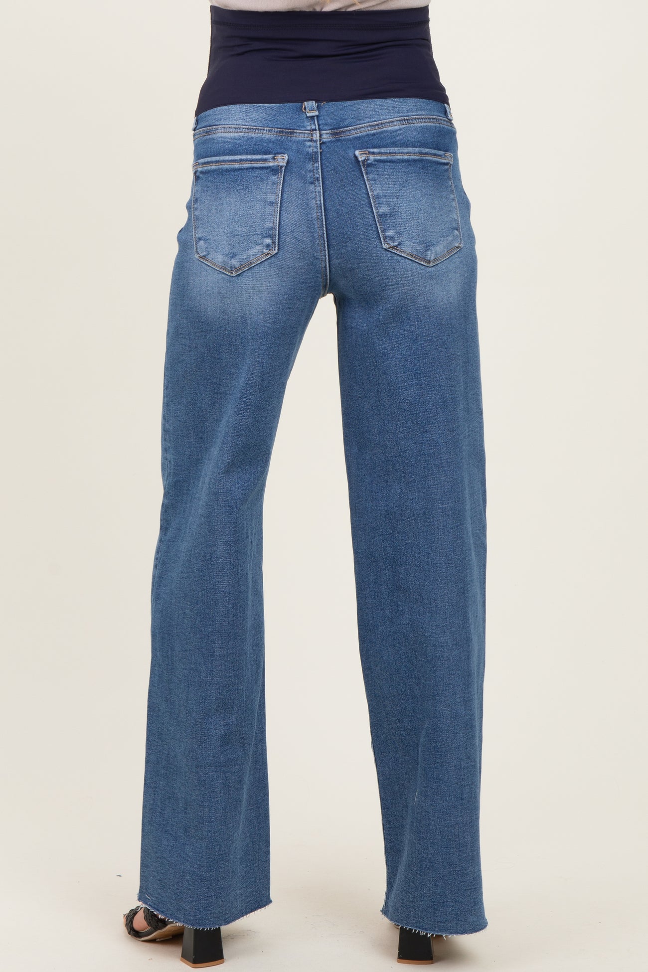 woman wearing blue maternity jeans with a high waist and wide-leg style, showing the back view