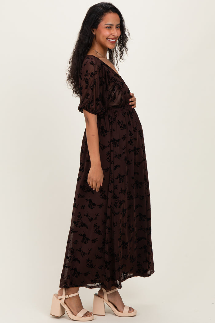 woman wearing a dark brown floral maternity dress with puff sleeves and a baby bump visible