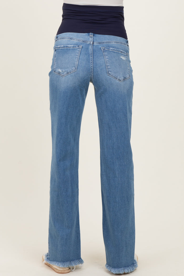 woman wearing light blue maternity jeans with a high waistband and frayed hem, facing away from the camera