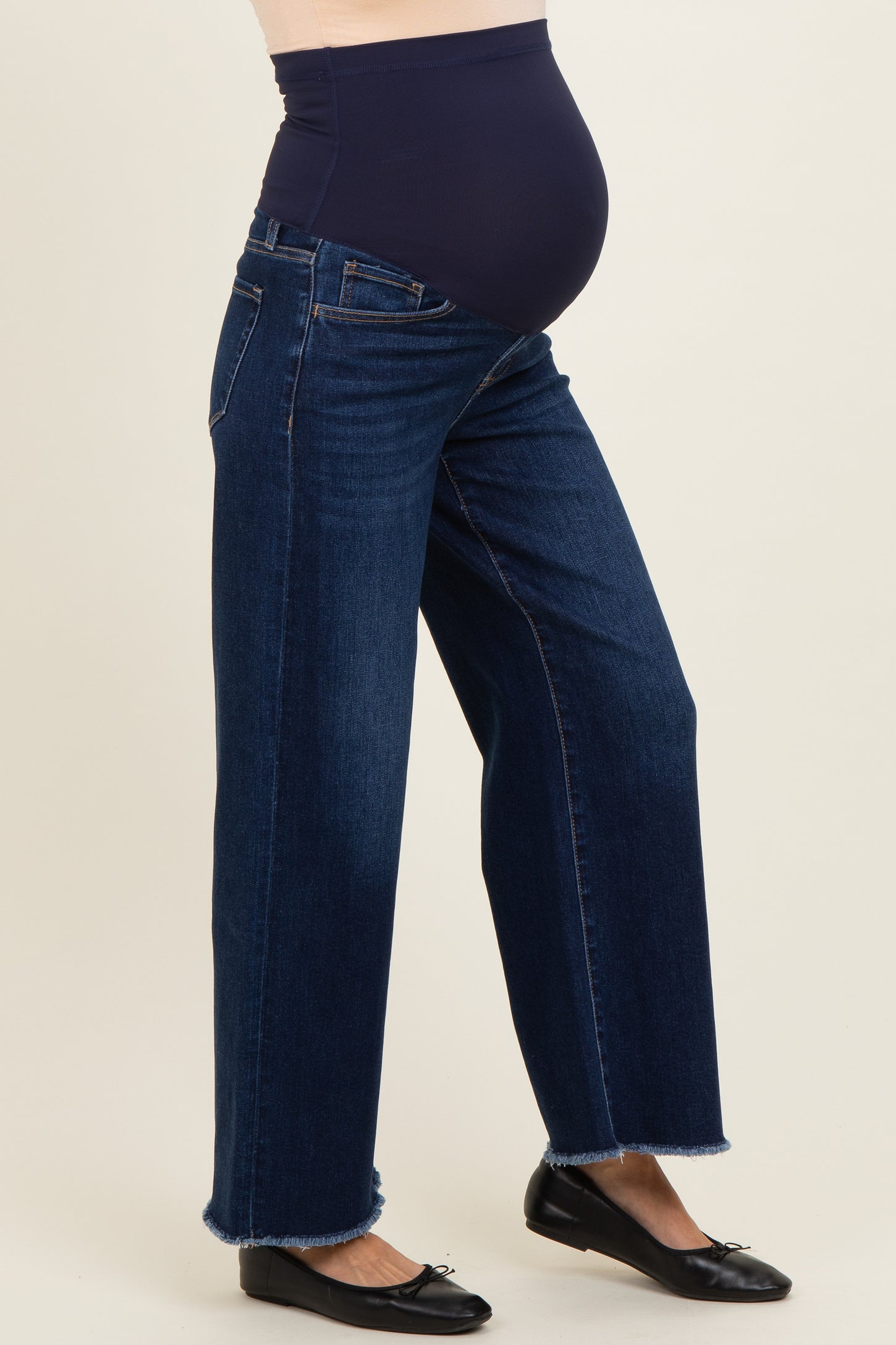woman wearing a dark blue maternity wide-leg jeans with a navy waistband and a visible baby bump