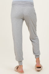 woman wearing gray maternity joggers with a relaxed fit and side pockets, showing the back view