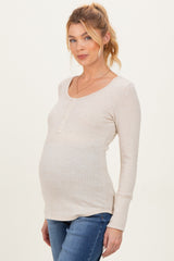 woman wearing a beige long sleeve maternity top with buttons and a visible baby bump