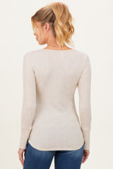woman wearing a beige long sleeve maternity top with a fitted style and ribbed texture, showing the back view