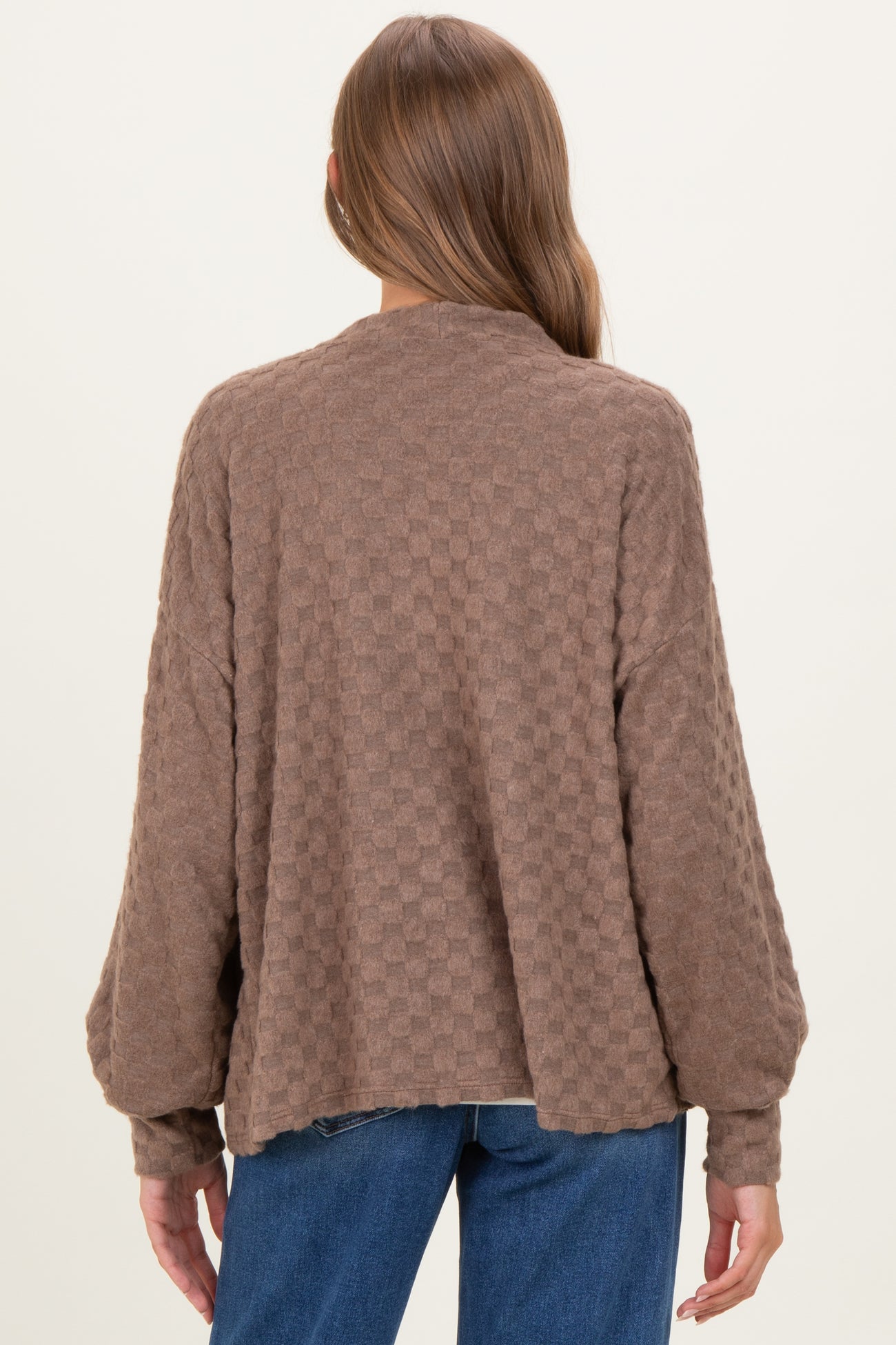 woman wearing a brown checkered maternity sweater with a relaxed fit and dropped shoulders, showing the back view