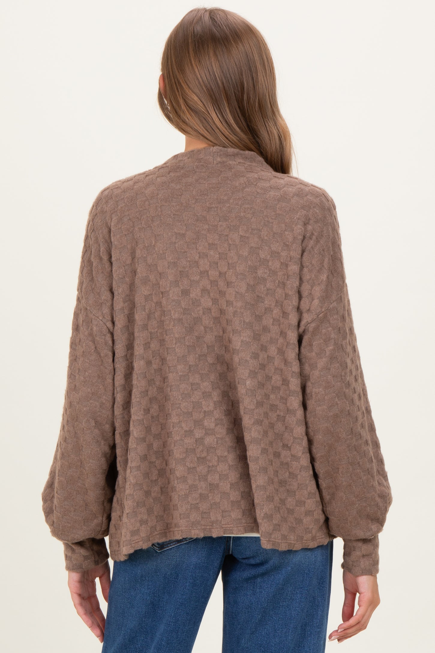 woman wearing a brown checkered maternity sweater with a relaxed fit and dropped shoulders, showing the back view
