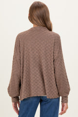 woman wearing a brown checkered maternity sweater with a relaxed fit and dropped shoulders, showing the back view