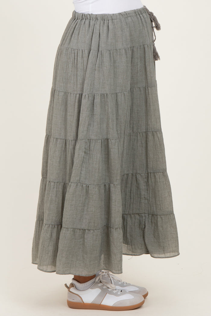 woman wearing a gray tiered maternity maxi skirt with a drawstring waist and paired with white sneakers