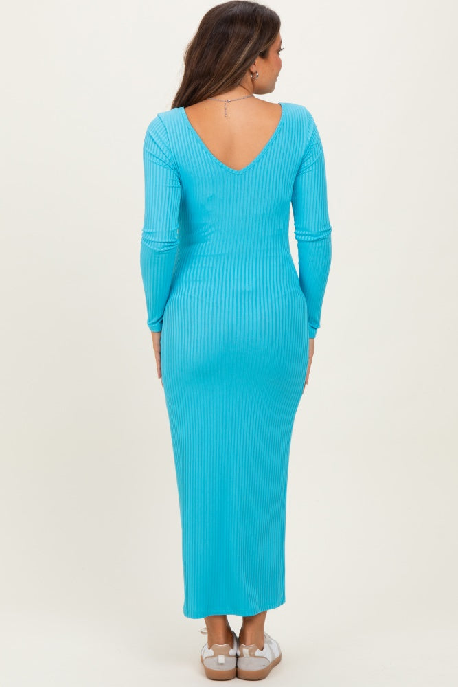 woman wearing a vibrant turquoise long sleeve maternity dress with a flattering v-back design