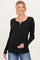 woman wearing a black long sleeve maternity top with buttons and holding her baby bump