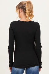 woman wearing a black long sleeve maternity top, viewed from the back with a ribbed texture