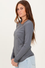 woman wearing a gray long sleeve top, styled with a round neckline and fitted silhouette, paired with light blue jeans