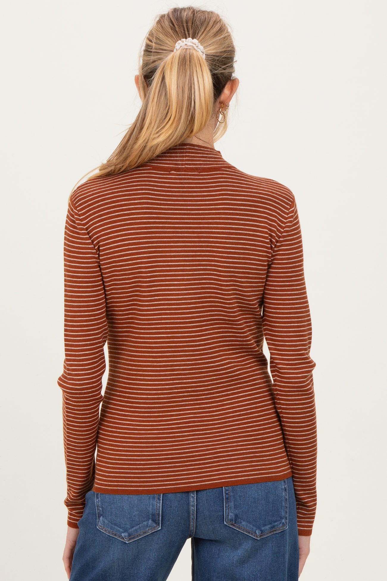 woman wearing a rust and cream striped maternity top with long sleeves, view from the back