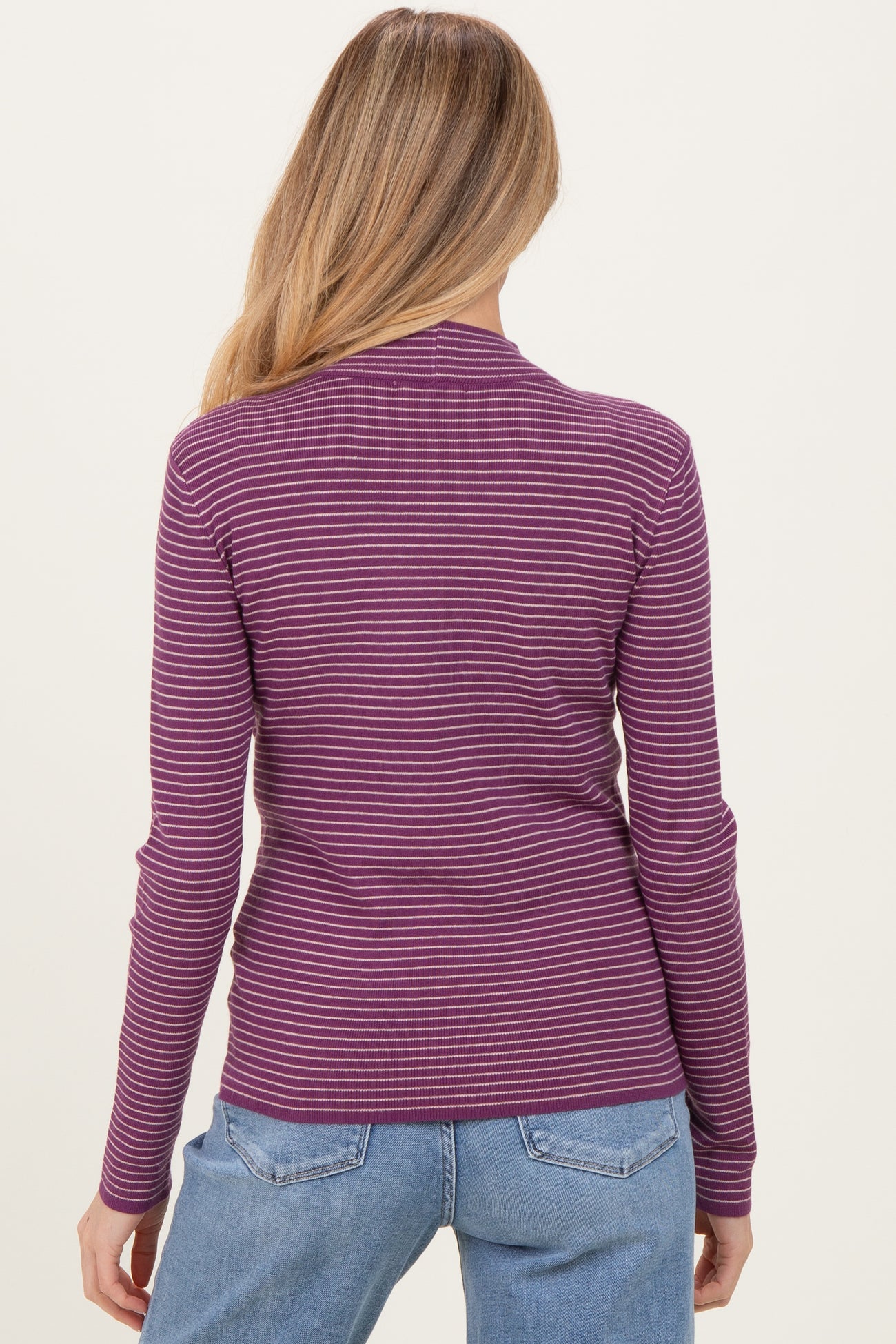 woman wearing a purple and pink striped long sleeve maternity top, showing the back view