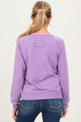woman wearing a purple maternity sweatshirt with a relaxed fit and long sleeves, shown from the back