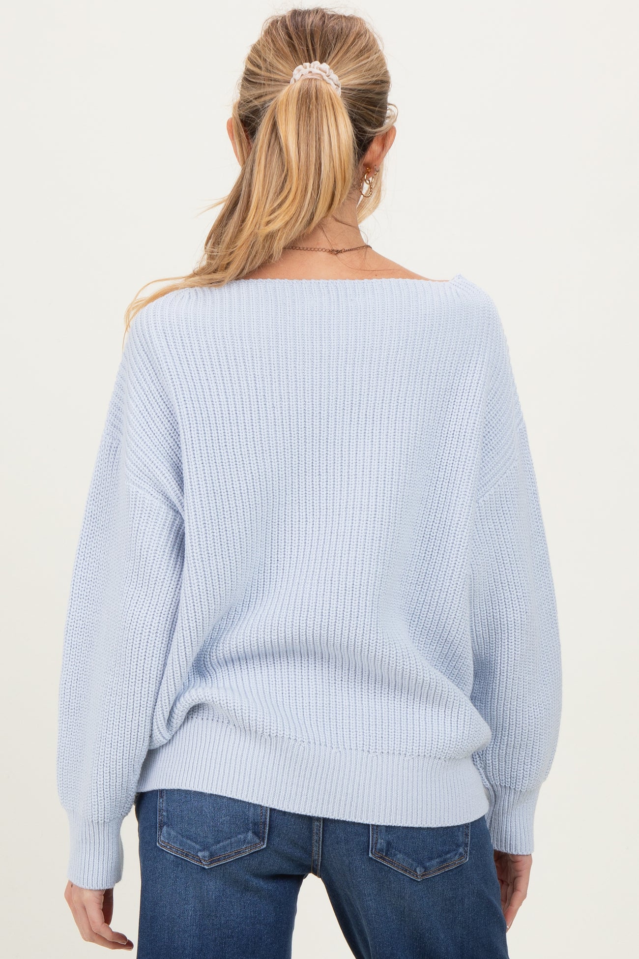 woman wearing a light blue oversized maternity sweater with balloon sleeves, viewed from the back