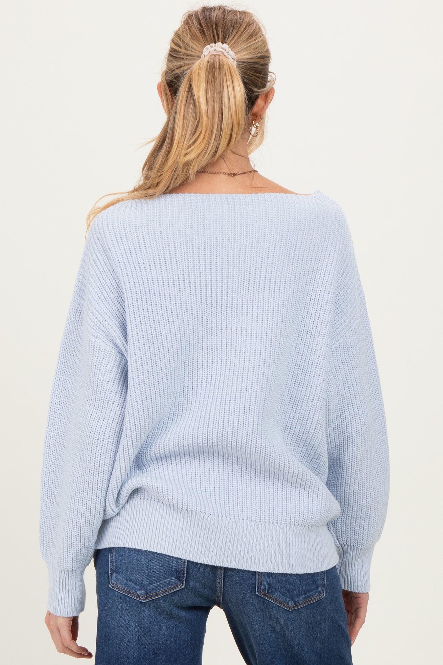 woman wearing a light blue oversized maternity sweater with balloon sleeves, viewed from the back