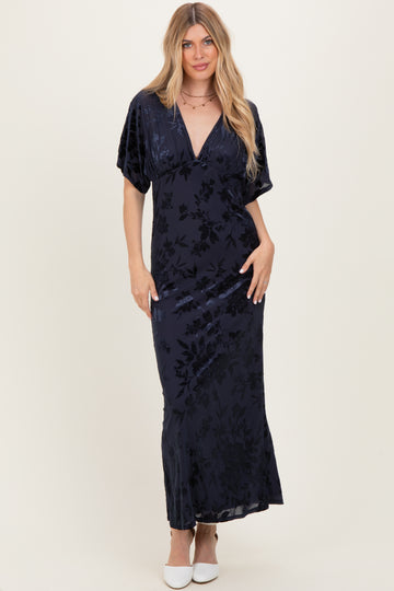 woman wearing a dark navy floral velvet maxi dress with short sleeves and a deep v-neckline