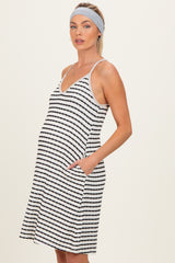woman wearing a black and white striped maternity sleeveless dress with pockets and a baby bump visible