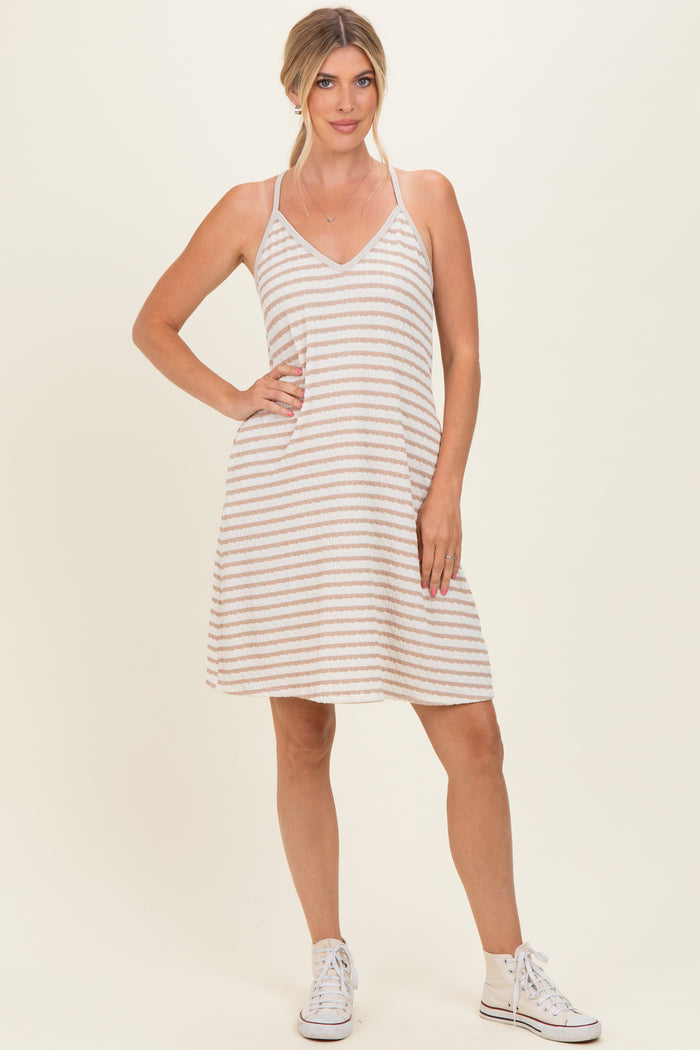 woman wearing a striped sleeveless sundress with a v-neckline and white sneakers
