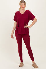 woman wearing a burgundy oversized v-neck top and matching leggings