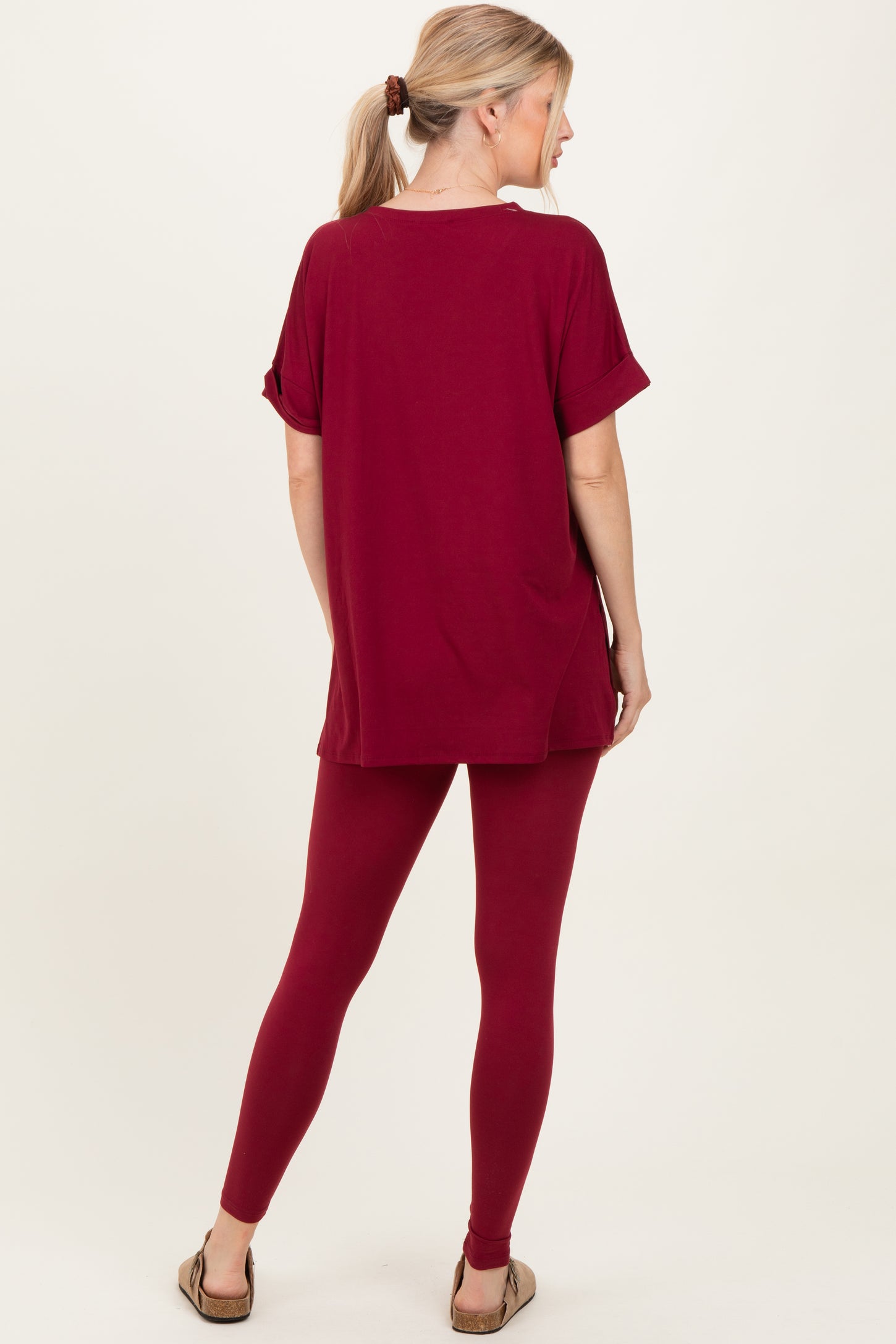 woman wearing a burgundy oversized t-shirt and matching leggings, viewed from the back