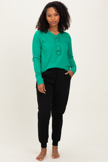 woman wearing a green long sleeve henley top and black jogger pants