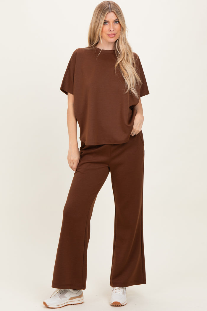 woman wearing a brown oversized t-shirt and matching wide-leg pants, styled with white sneakers