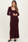woman wearing a burgundy long sleeve ribbed maternity dress with a scoop neckline and visible baby bump