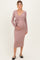 woman wearing a mauve long sleeve maternity dress with a tied waist and holding her baby bump