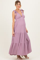 woman wearing a lavender striped maternity maxi dress with tie shoulder straps and a visible baby bump
