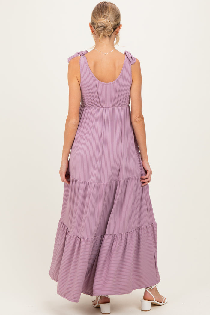 woman wearing a lavender maternity maxi dress with tie straps and tiered ruffles from the back