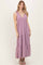 woman wearing a lavender maxi dress with a deep v-neck and tiered ruffle hem, styled with a shoulder tie detail