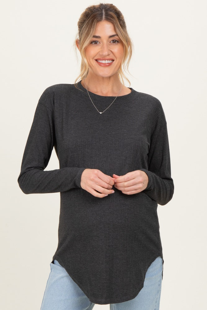 woman wearing a dark grey long sleeve maternity top with a curved hem and a visible baby bump