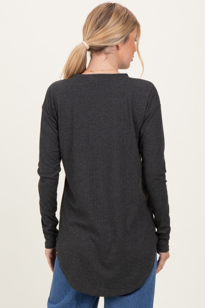 woman wearing a dark gray long sleeve top with a curved hem and relaxed fit, seen from the back