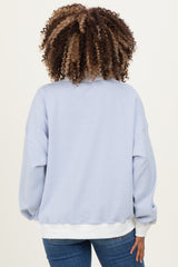 woman wearing a light blue striped maternity sweatshirt with a relaxed fit and white hem, shown from the back