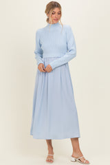 woman wearing a light blue cropped sweater and a flowing light blue maxi skirt