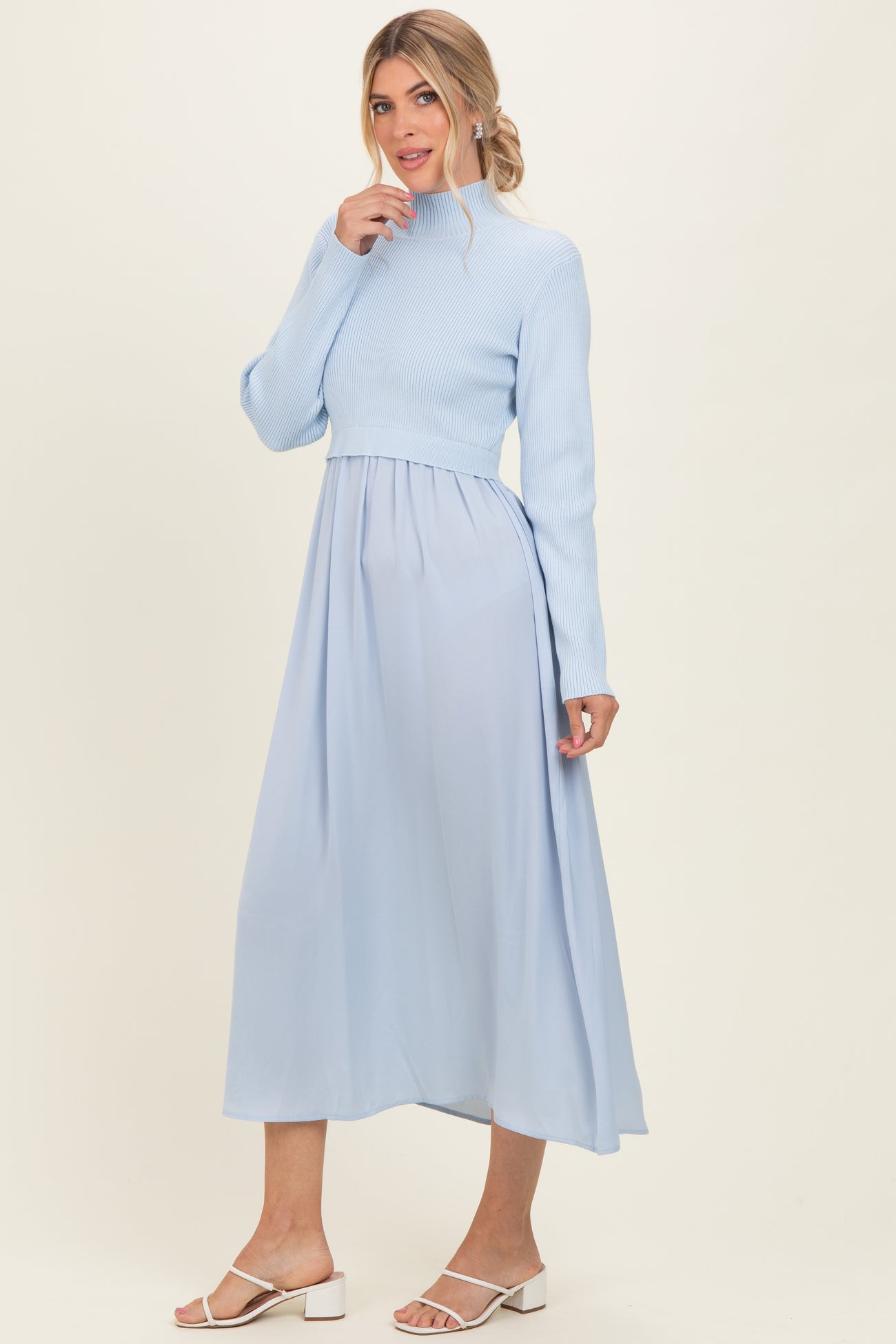 woman wearing a light blue mock neck knit top with a flowy maxi skirt in the same color