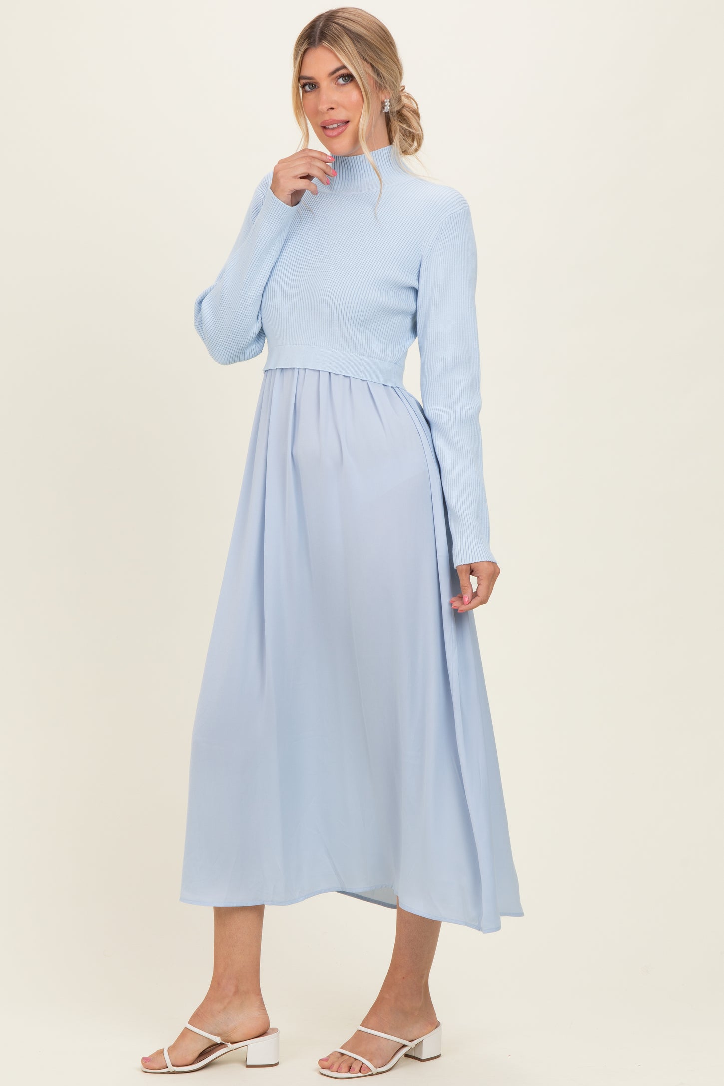 woman wearing a light blue mock neck knit top with a flowy maxi skirt in the same color