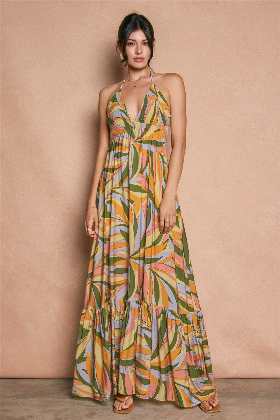 woman wearing a colorful maxi dress with a halter neck and tiered ruffled hem