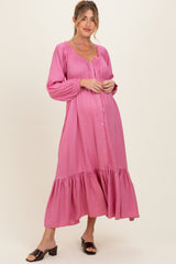 woman wearing a pink maternity dress with long sleeves and ruffled hem, featuring a button-down front